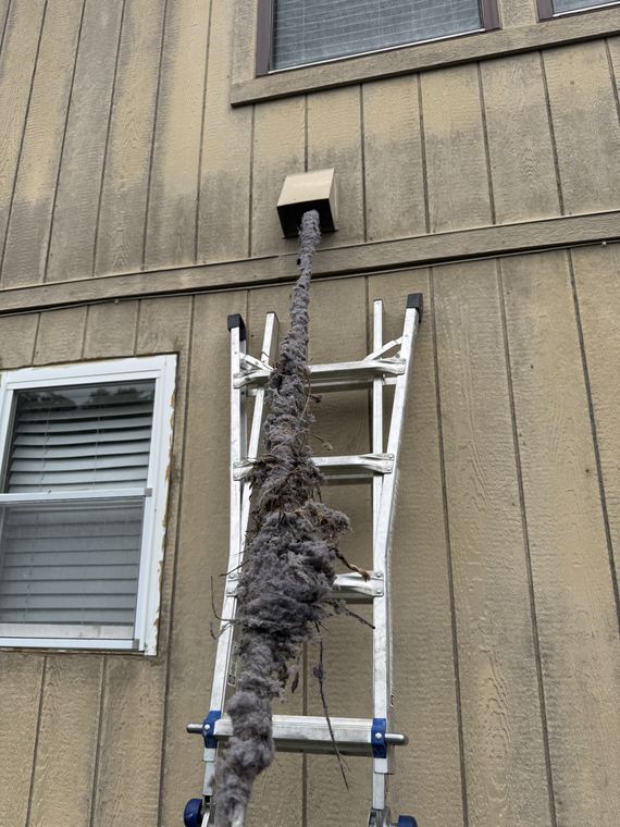 A full lint clog pulled out of an exterior roof-height dryer vent on a Kansas City home